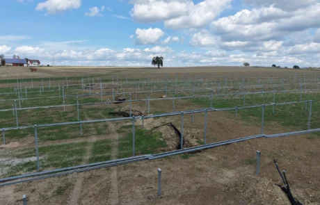 Luftbild des Baufelds mit Pfostenreihen und Hohenloher Landschaft im Hintergrund, Solarpark Mulfingen II mit 9.750 kWp