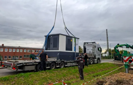 Kran hebt Trafostation auf der PV-Baustelle Rödinghausen an